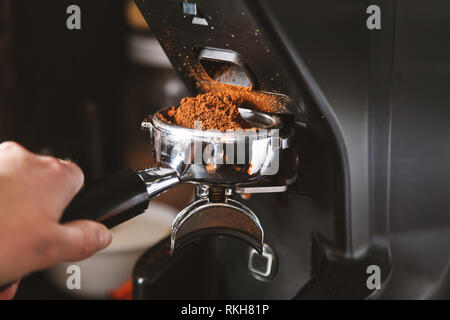 Le broyage à l'aide de grains de café barista, machine à café, moulin à café fraîchement torréfié haricots faire broyer en une poudre. Banque D'Images