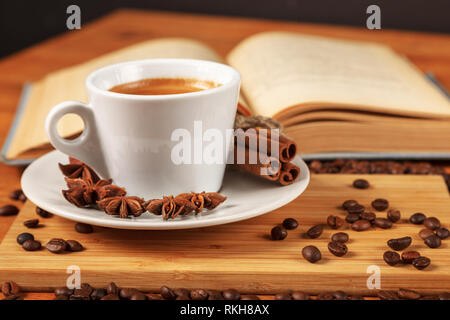 Pause café avec une tasse de café fort chaud sur une table en bois avec un vieux livre recouvert de tissu. Une tasse de café noir blanc entouré d'un s Banque D'Images