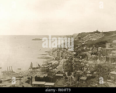 À l'ouest, le long du front de mer à Hastings, East Sussex, Angleterre dans l'ère victorienne, c.1900. Au premier plan est la vieille ville et les deux Hastings et St Leonards piers sont visibles en arrière-plan. La plage de galets à gauche est le stade, la maison pour sa plage-lancé flotte de pêche. Le caractère distinctif de hauteur, noir (en bas au centre) ont été utilisés pour loger les filets pour attraper le maquereau et le hareng. Banque D'Images