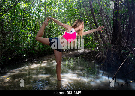 Young woman practicing yoga (Lord of the Dance - Natarajasana) dans un cadre naturel - Fort Lauderdale, Floride, USA Banque D'Images