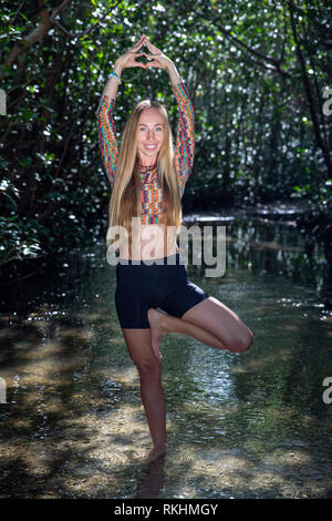 Young woman practicing yoga (Posture de l'arbre - Vrksasana) dans un cadre naturel - Fort Lauderdale, Floride, USA Banque D'Images