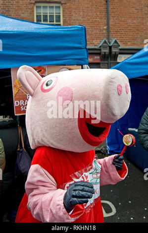 Une personne vêtue de Peppa Pig tenant un tambour chinois pendant les célébrations du nouvel an 2019 chinois pour célébrer l'année du Pig. Banque D'Images