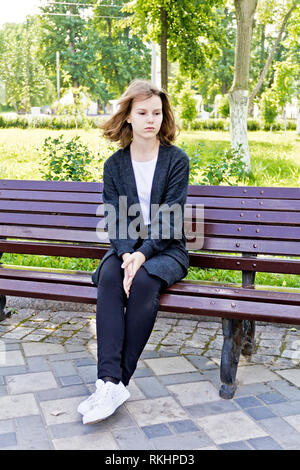 Sad girl 14 ans sont assis sur le banc Banque D'Images