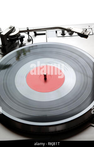 Vintage turntable en cas d'argent avec des boutons et des boutons sur le tableau de contrôle avec un disque vinyle avec étiquette rouge isolé sur fond blanc. Vue de dessus fermer Banque D'Images