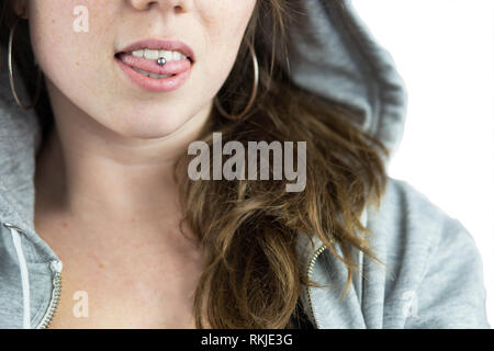 Jeune fille de l'adolescence avec la perforation de langue et hoodie Banque D'Images