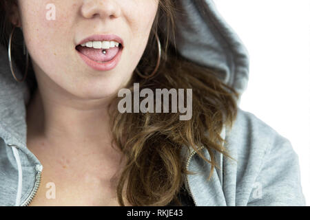 Jeune fille de l'adolescence avec la perforation de langue et hoodie Banque D'Images