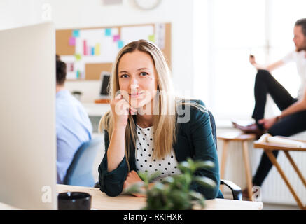 Un portrait of young businesswoman sitting in a modern office. Banque D'Images