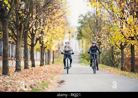 Un couple avec electrobikes vélo en plein air sur une route. Banque D'Images