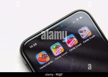 Quatre Candy Crush Saga jeux sur un iPhone X sur un fond blanc. Les quatre jeux de bonbons sont fait par le roi. Banque D'Images