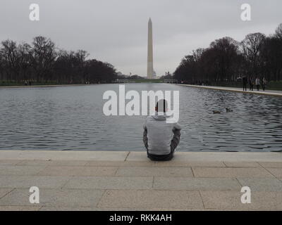 L'homme siège par la Reflecting Pool au Lincoln Memorial à Washington DC - USA Banque D'Images
