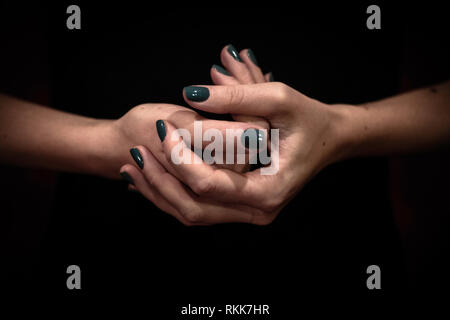 Les mains des femmes détenant ensemble libre shot des mains avec des ongles peints en vert Banque D'Images