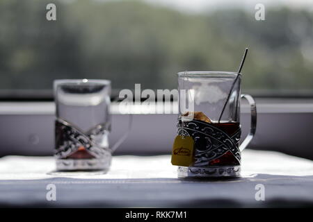 Deux tasses de thé en metal ancien porte-tasses sur la table dans le train Voyager en Ukraine. Banque D'Images