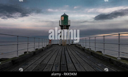 L'Abbaye de Whitby pier avec phare à la fin. Mer avec beau ciel sur l'arrière-plan. Banque D'Images