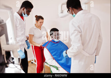 L'équipe médecins multiraciale. Les médecins hommes afro-américains avec un portrait de femmes. L'uniforme professionnel prendre x-ray de patient. Banque D'Images