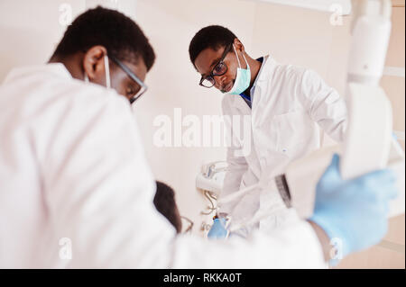 Les médecins hommes afro-américains en uniforme professionnel prendre x-ray de patient. Banque D'Images