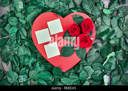 Coeur rouge saint valentin coeur rouge rose. avec des roses sur un fond de feuilles de roses avec des autocollants pour le texte. carte de vœux et élément de conception Banque D'Images