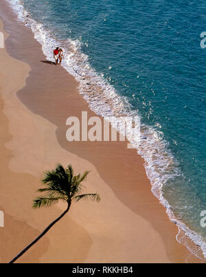 Couple marchant le long d'une plage sur une île tropicale. Banque D'Images