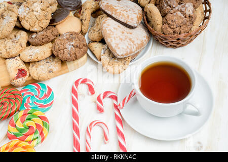 Sweet cookies, the go et une tasse de thé sur une table en bois blanc. Banque D'Images