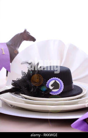 Les courses de chevaux Chers fine déjeuner table à manger avec petit fascinator hat noir, décorations et champagne, avec des reflets. Banque D'Images