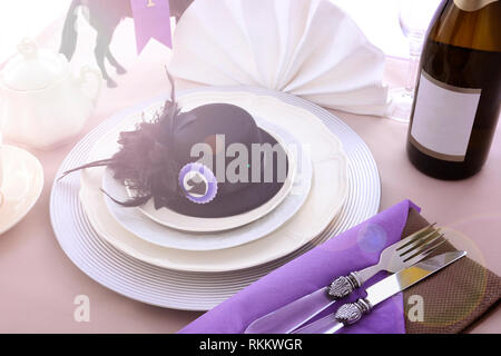 Les courses de chevaux Chers fine déjeuner table à manger avec petit fascinator hat noir, décorations et champagne, avec des reflets. Banque D'Images