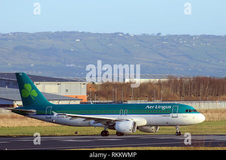 Un Airbus A320 d'Aer Lingus se prépare à décoller de l'aéroport de Belfast, Irlande du Nord. L'Airbus A320 se compose de courte à moyenne portée, à fuselage étroit, bimoteur de transport commercial de passagers jet airlinersmanufactured par Airbus. La famille comprend l'A318, A319, A320 et A321, ainsi que l'ACJ de business jet. Les A320 sont aussi nommées A320ceo (option moteur actuel) après l'introduction de l'A320neo (option nouveau moteur) l'assemblage final de la famille a lieu à Toulouse, France, et Hambourg, Allemagne. Une usine à Tianjin, Chine, produit également des avions pour les compagnies aériennes chinoises Banque D'Images