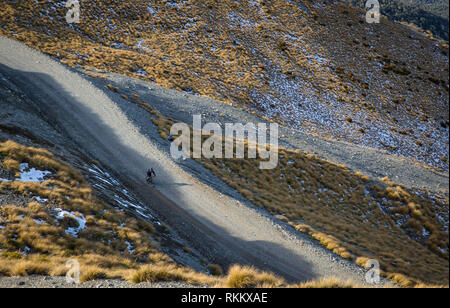 Un vélo de montagne descend la montagne le long de la route sur un domaine skiable de frosty matin à Canterbury, Nouvelle-Zélande Banque D'Images