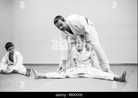 Les enfants en kimono commencer la formation sur l'aikido. Banque D'Images