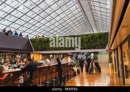 Paris CDG Airport - 12/22/18 : Terminal 2F food court, grand skylight maille avec vivre la végétation, jardin vertical et un bar. Les personnes voyageant avec suitc Banque D'Images