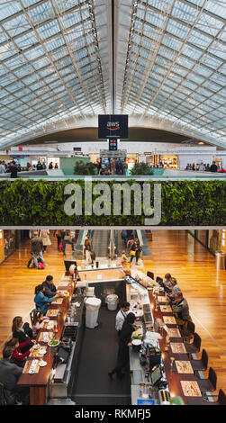 Paris CDG Airport - 12/22/18 : Terminal 2F food court, grand skylight maille avec vivre la végétation, jardin vertical et un bar. Les personnes voyageant avec suitc Banque D'Images