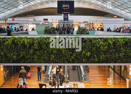 Paris CDG Airport - 12/22/18 : Terminal 2F food court, grand skylight maille avec vivre la végétation, jardin vertical et un bar. Les personnes voyageant avec suitc Banque D'Images