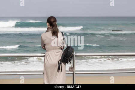 Vue arrière du smartly dressed man looking out to sea Banque D'Images