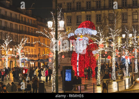 Lisbonne, Portugal - 26/12/18 : Santa géant statue in Baixa Chiado, boules rouges de décorations de noël.Nuit illuminations. Les arbres illuminés et Santa Banque D'Images