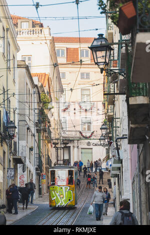 Lisbonne, Portugal - 01/03/19 : Câble électrique tram ascenseur monter et descendre sur une colline. Beaucoup de gens dans la rue étroite avec des bâtiments Câbles et ba Banque D'Images