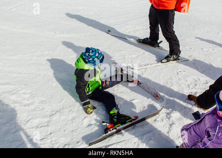 Sheregesh, montagne de Shoria, Moscow, Russie - 6 Avril, 2018 : little boy mountain ski rider assis sur la pente Banque D'Images