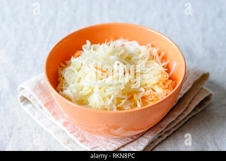 Orange Bowl avec choucroute croquant servi sur des nappes avec fourches sur table Banque D'Images