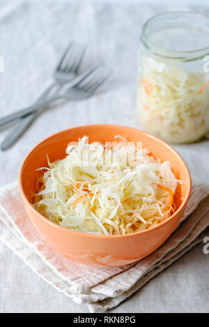 Orange Bowl avec choucroute croquant servi sur des nappes avec fourches sur table Banque D'Images