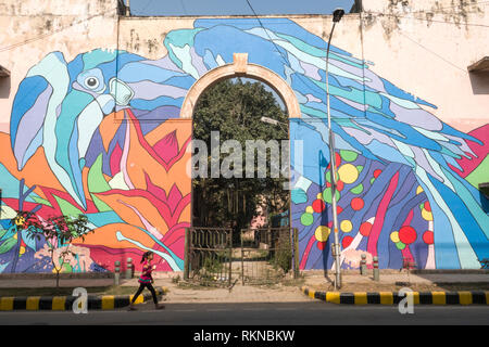 Une fille passe devant une peinture murale de la rue d'un Calao Pie Oriental par Renato Reno de Lodhi Colony, New Delhi, Inde Banque D'Images