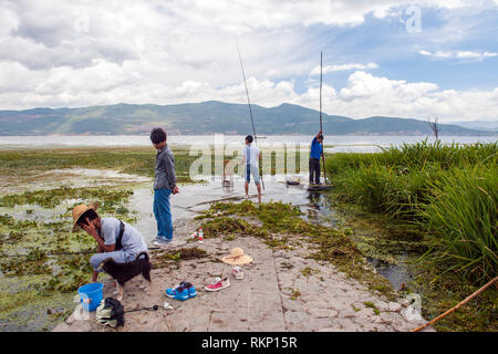 Les gens de la pêche par les rives du lac Erhai près de Dali dans la province du Yunnan, Chine. Banque D'Images