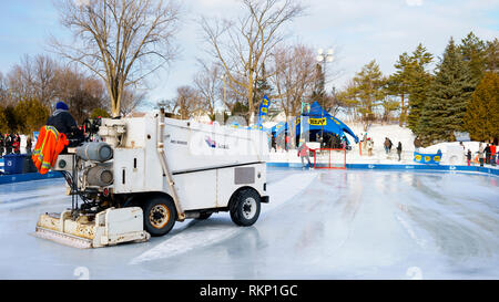 Surfaceuse Zamboni le nettoyage de la glace sur une patinoire en plein air. Banque D'Images