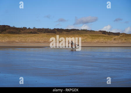 L'équitation sur la plage de Newton, près de Porthcawl, Nouvelle-Galles du Sud Banque D'Images