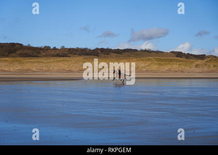 L'équitation sur la plage de Newton, près de Porthcawl, Nouvelle-Galles du Sud Banque D'Images