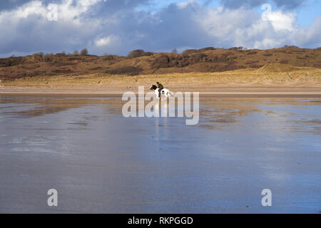 L'équitation sur la plage de Newton, près de Porthcawl, Nouvelle-Galles du Sud Banque D'Images