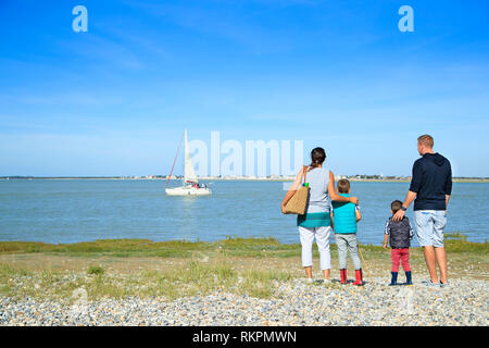 Baie de Somme (nord de la France) : famille avec deux enfants face à la mer, à la recherche d'un voilier sur l'eau, à Saint-Valery-sur-Somme, le long de la zone côtière Banque D'Images