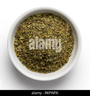 Haché séché les herbes de Provence dans un bol en céramique blanc isolé sur blanc de ci-dessus. Banque D'Images