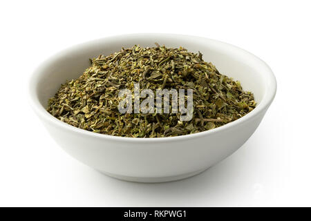 Haché séché les herbes de Provence dans un bol en céramique blanc isolé sur blanc. Banque D'Images