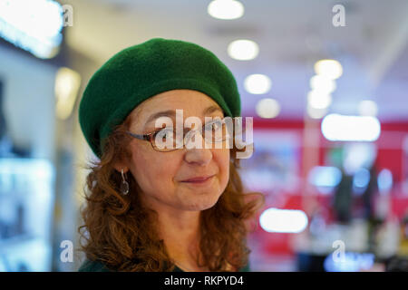 Closeup of a mature woman in green cap à l'intérieur Banque D'Images