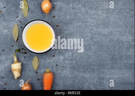 Avec des ingrédients du bouillon.bouillon clair est fait par immersion ou d'os de viande ou de légumes. Préparé avec du poivre, l'oignon, carotte, céleri, persil racine.La nourriture. Banque D'Images