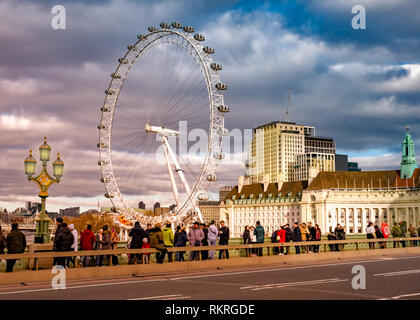 Londres, Royaume-Uni - 10 janvier 2019 : les touristes visitant Londres en face de la célèbre Eye whell, entre la rivière Thames, éclairé par la lumière au coucher du soleil Banque D'Images