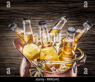 Bouteilles de bière froide dans les cubes de glace dans le seau à glace à l'ancienne. Banque D'Images