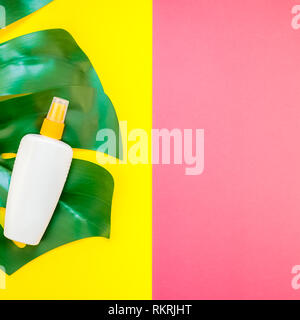 Jungle tropicale Feuilles monstera palmier bouteille vide de l'écran solaire et immersive sur carré lumineux jaune et rose papier duotone arrière-plan. Vacances d'été cre Banque D'Images